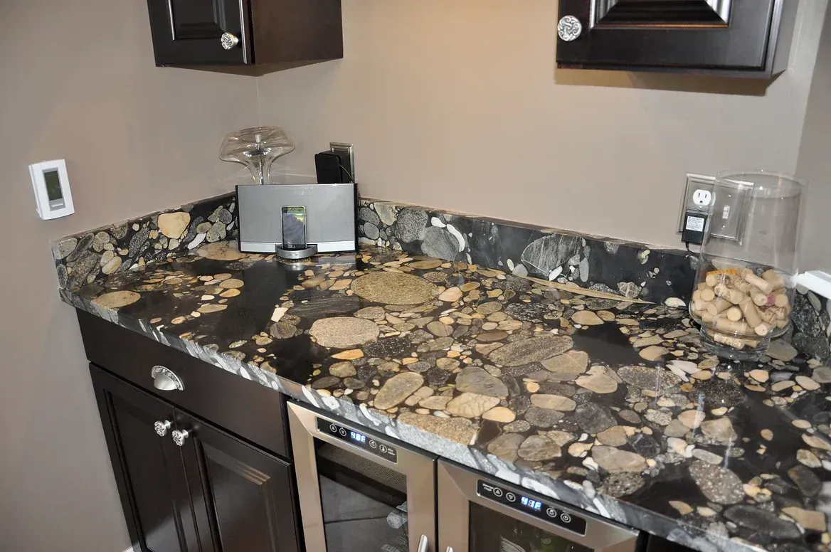 A kitchen with a granite counter top and stainless steel appliances.