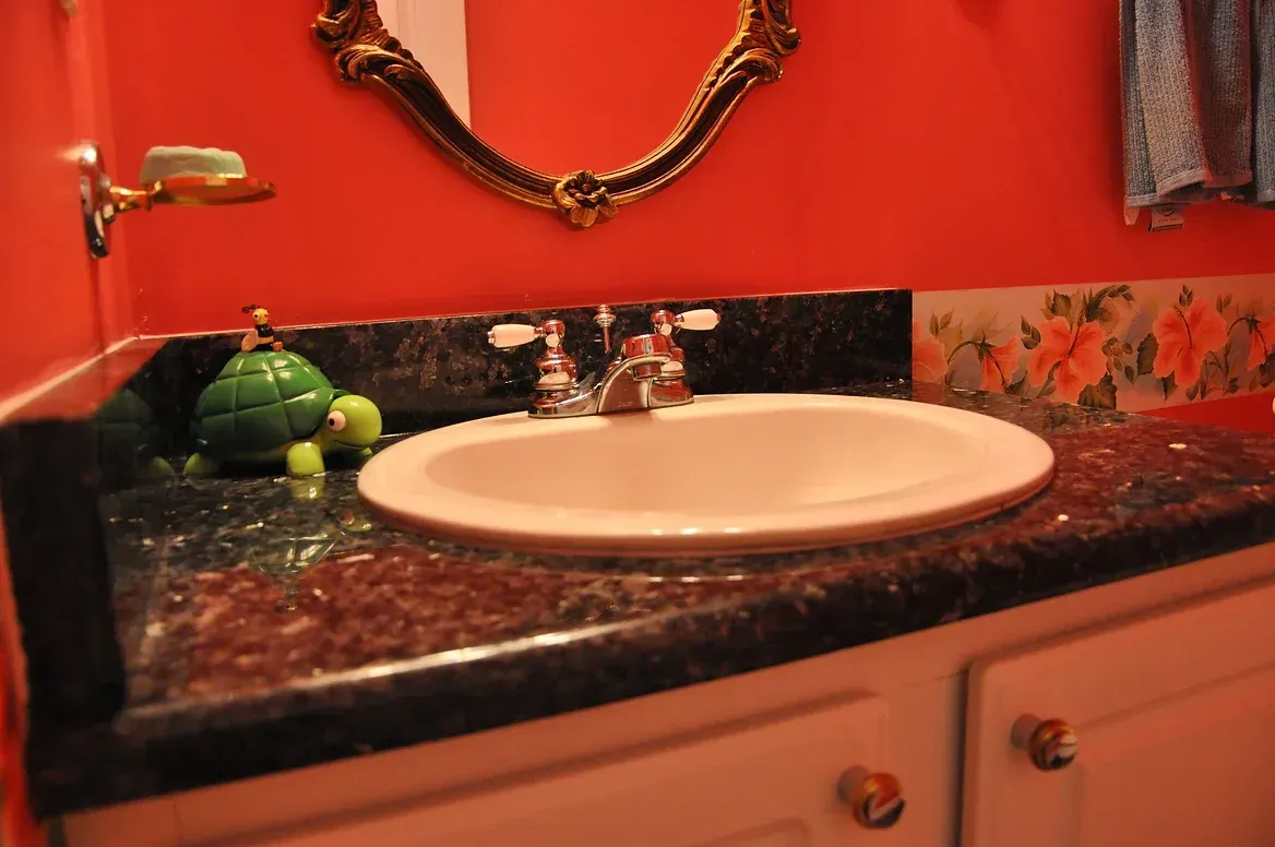 A bathroom with a sink and a mirror on the wall