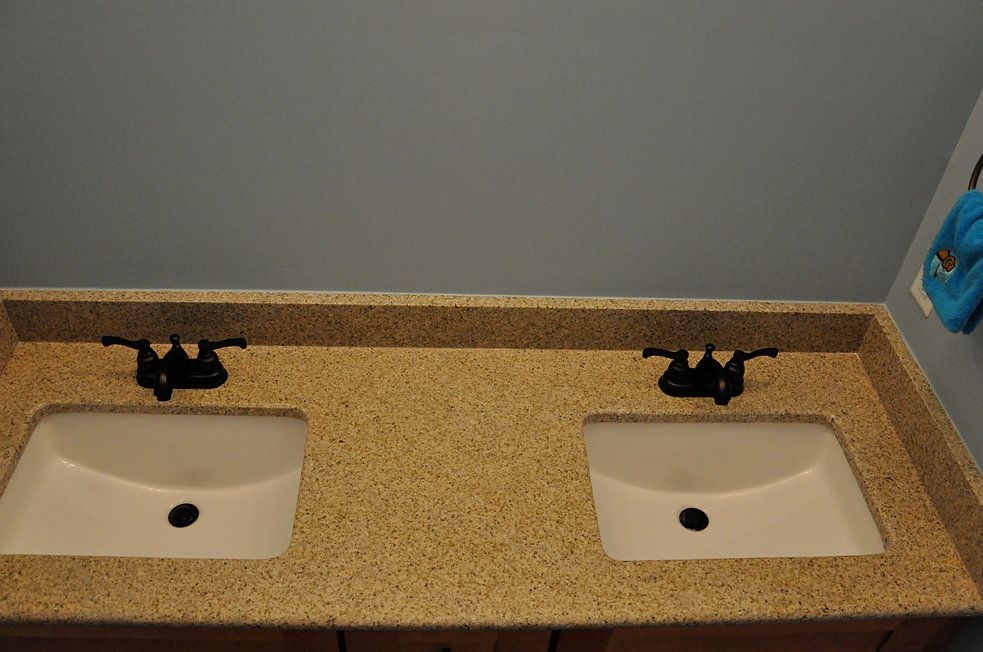 A bathroom with two sinks and a blue towel hanging on the wall.
