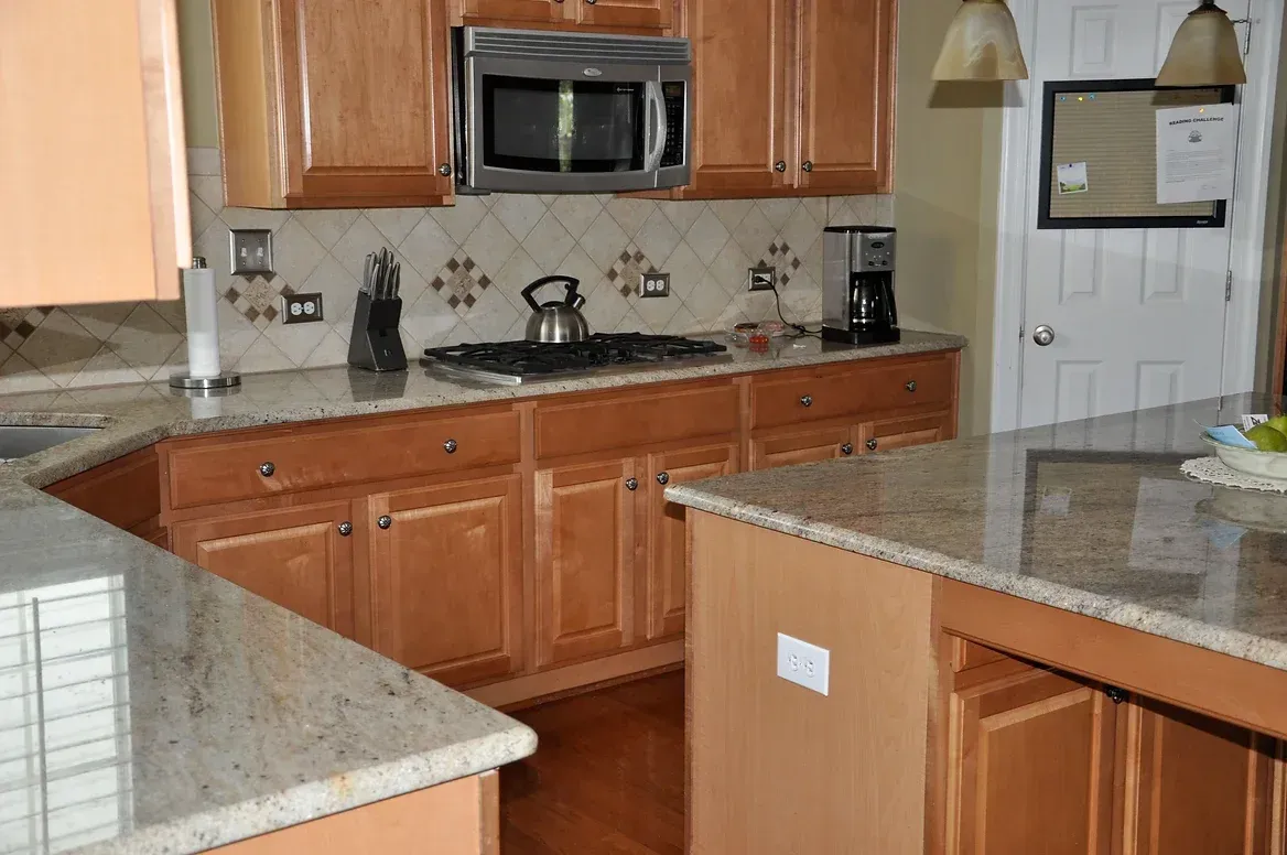 A kitchen with wooden cabinets and granite counter tops