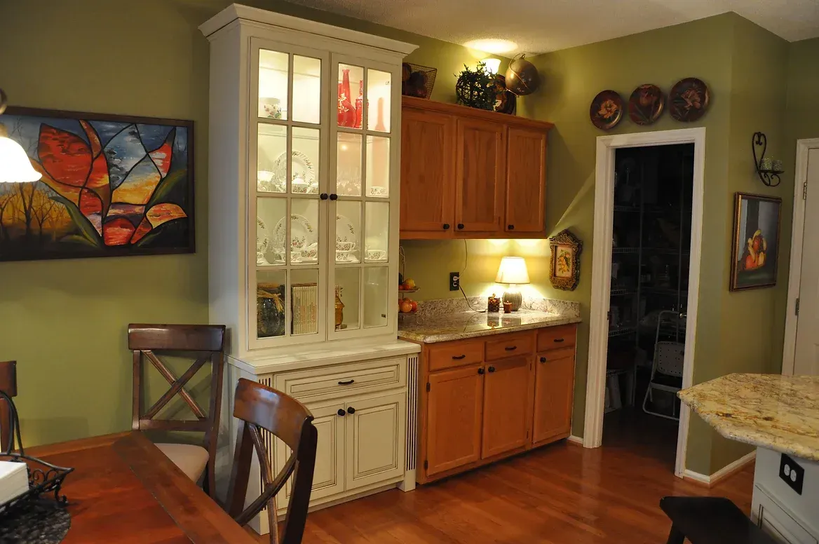 A dining room with a table and chairs and a hutch