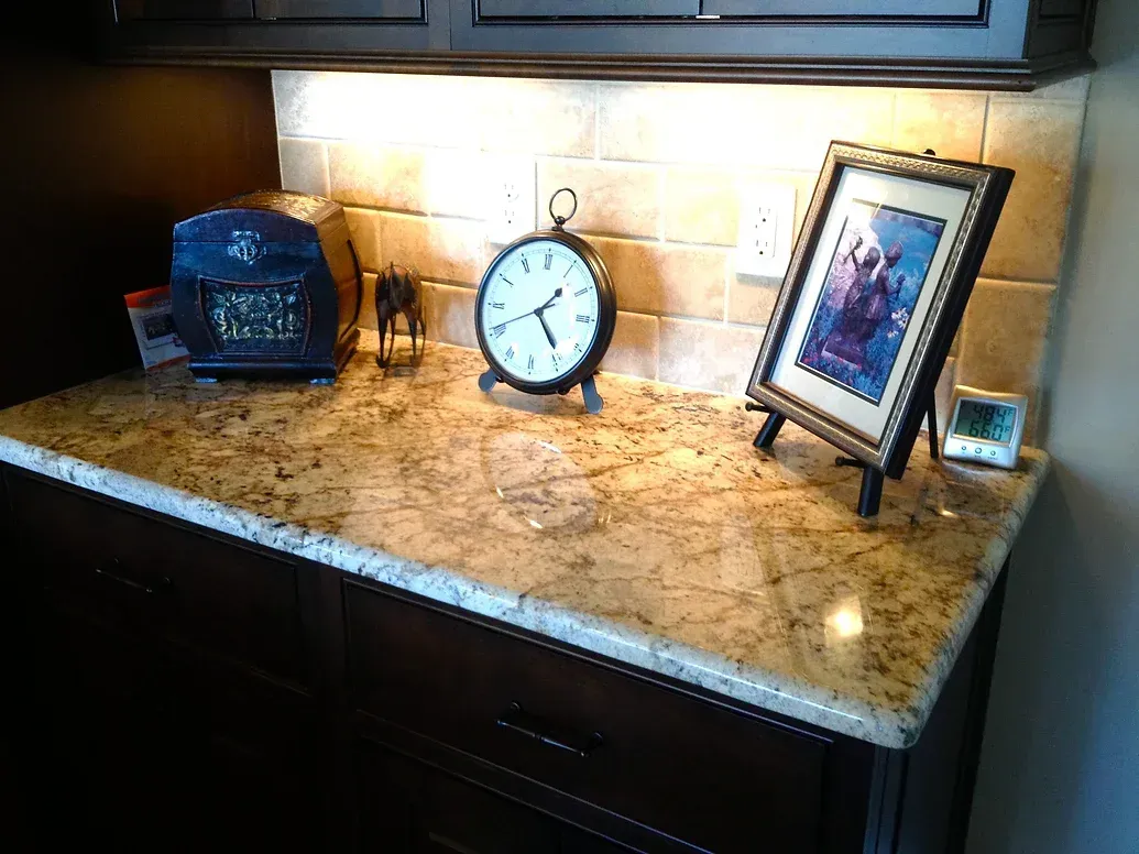 A clock is sitting on a counter next to a picture.