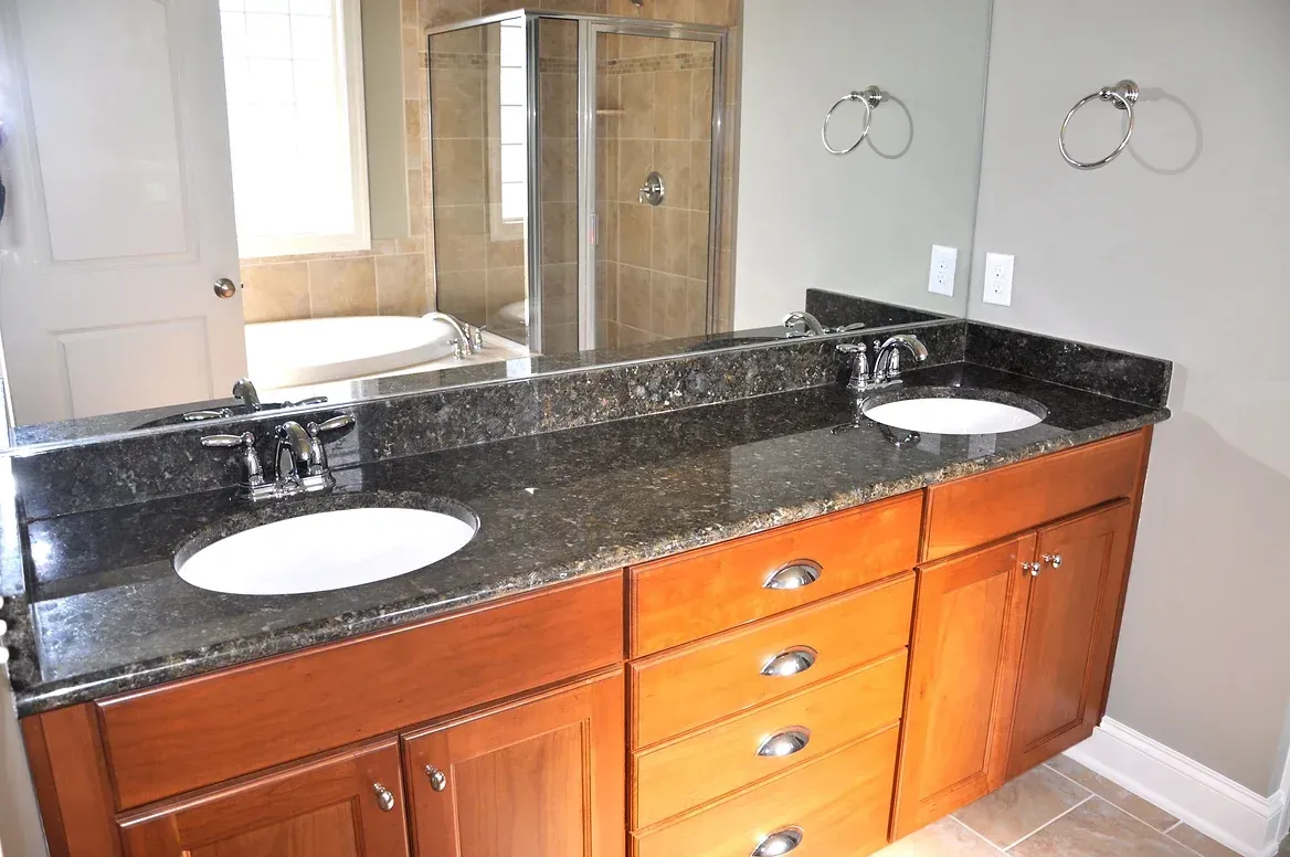 A bathroom with two sinks and a large mirror.