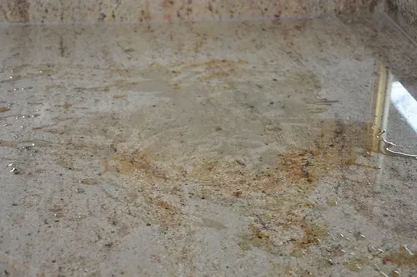 A close up of a marble counter top with a bottle of water on it.