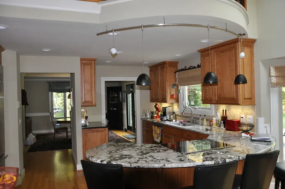 A kitchen with granite counter tops and wooden cabinets