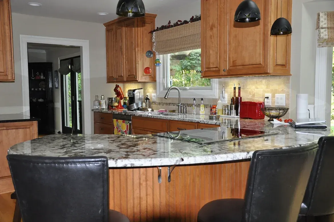 A kitchen with a granite counter top and wooden cabinets
