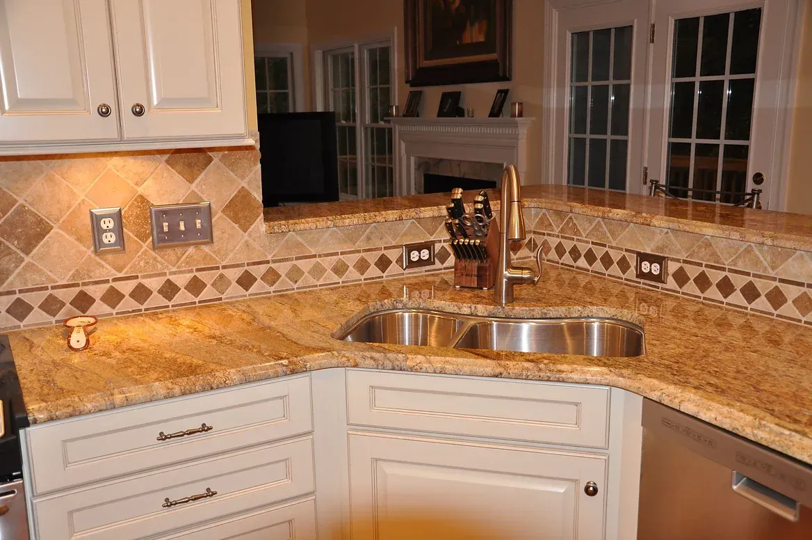 A kitchen with granite counter tops and a stainless steel sink