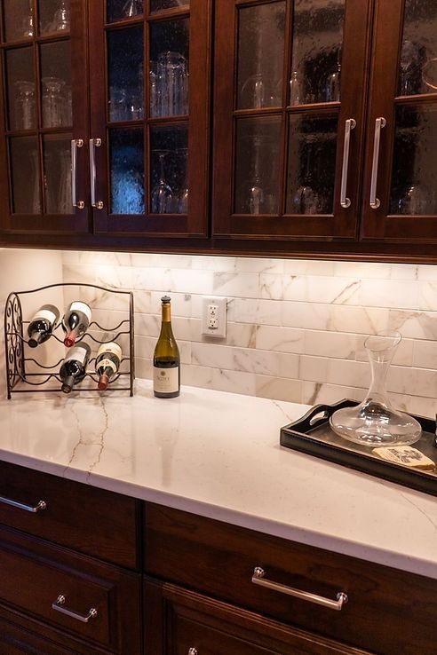 A kitchen counter with a wine rack and a bottle of wine on it.