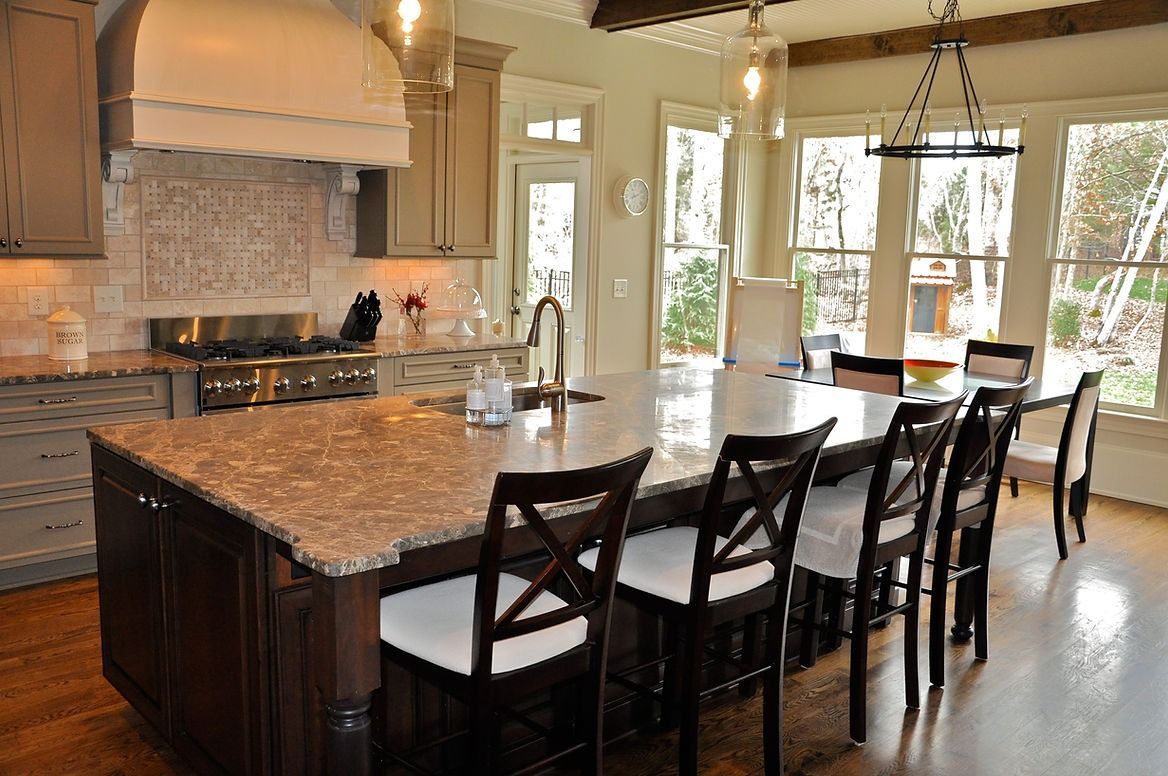 A kitchen with a large island and a dining table.