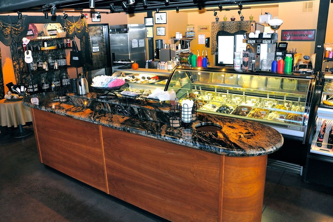 A bakery with a large wooden counter and a display case filled with food.