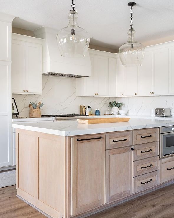 A kitchen with white cabinets and a large island