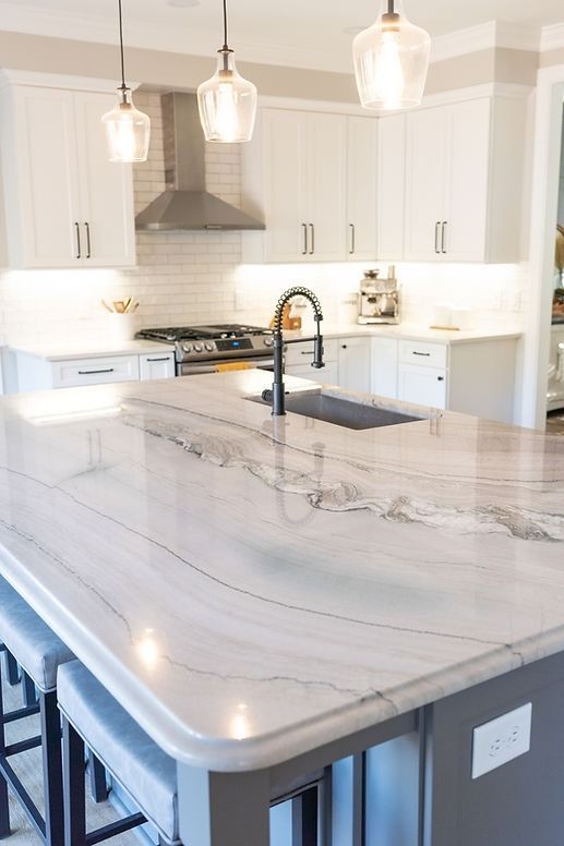 A kitchen with a large island and a sink.