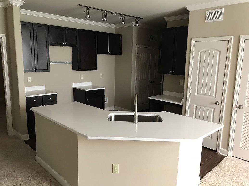 An empty kitchen with a large island and a sink
