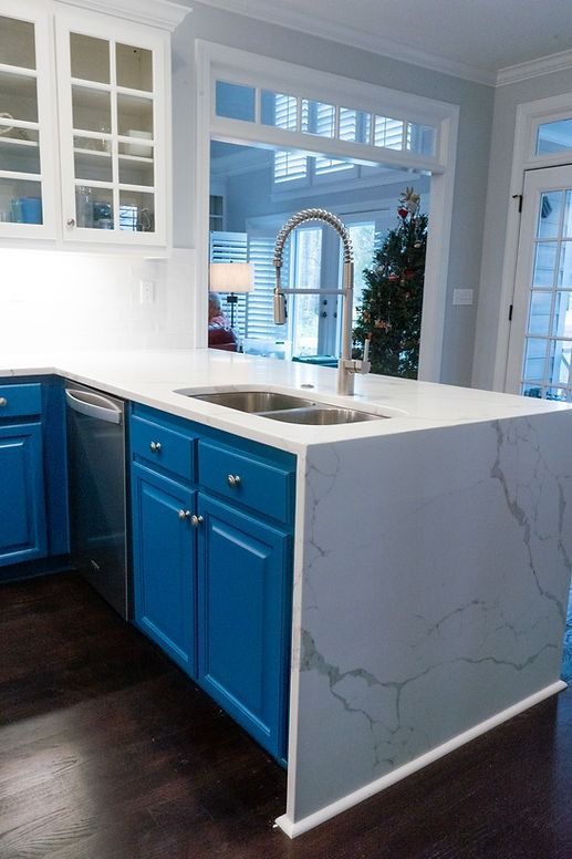 A kitchen with blue cabinets and a white counter top