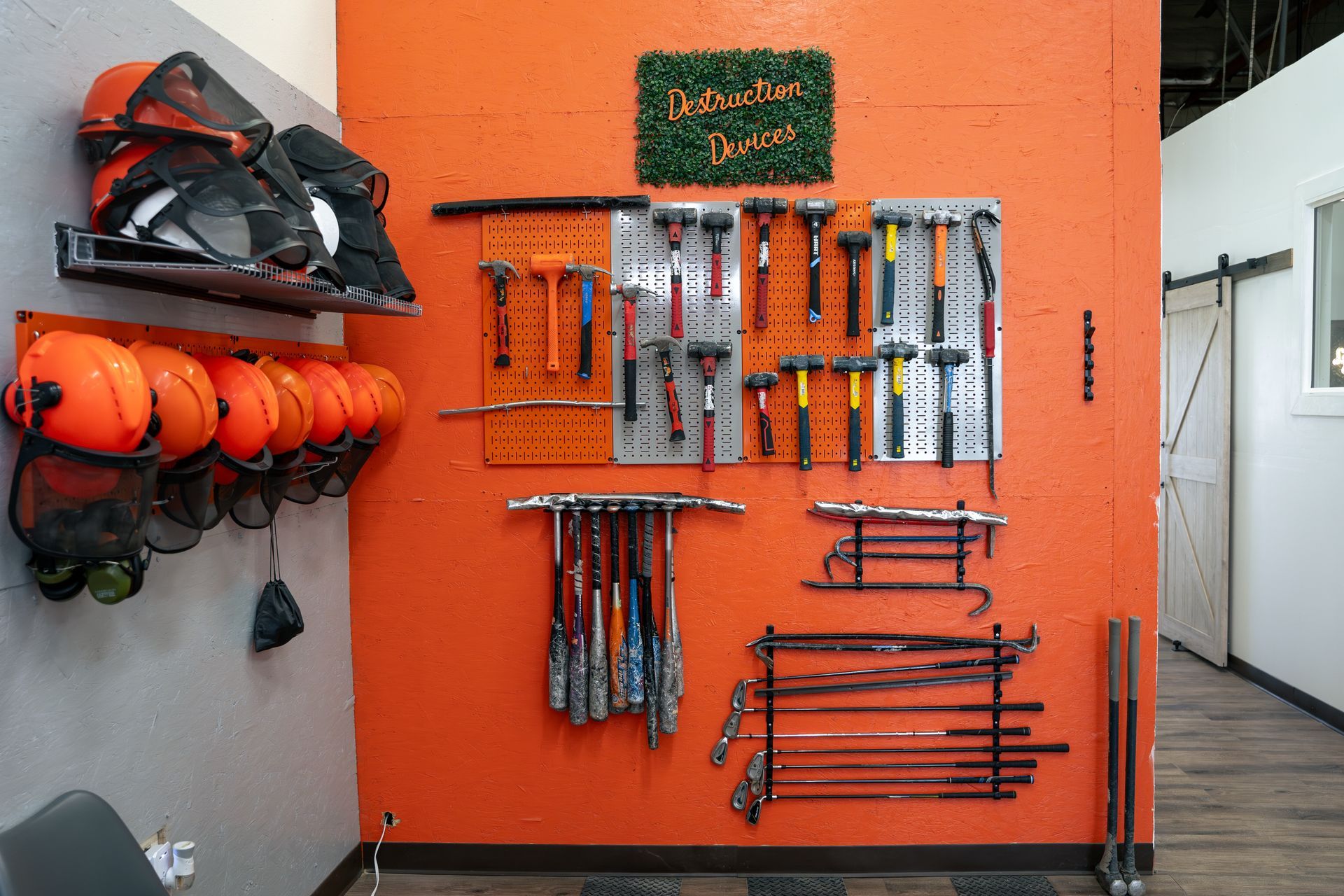A bunch of tools hanging on an orange wall