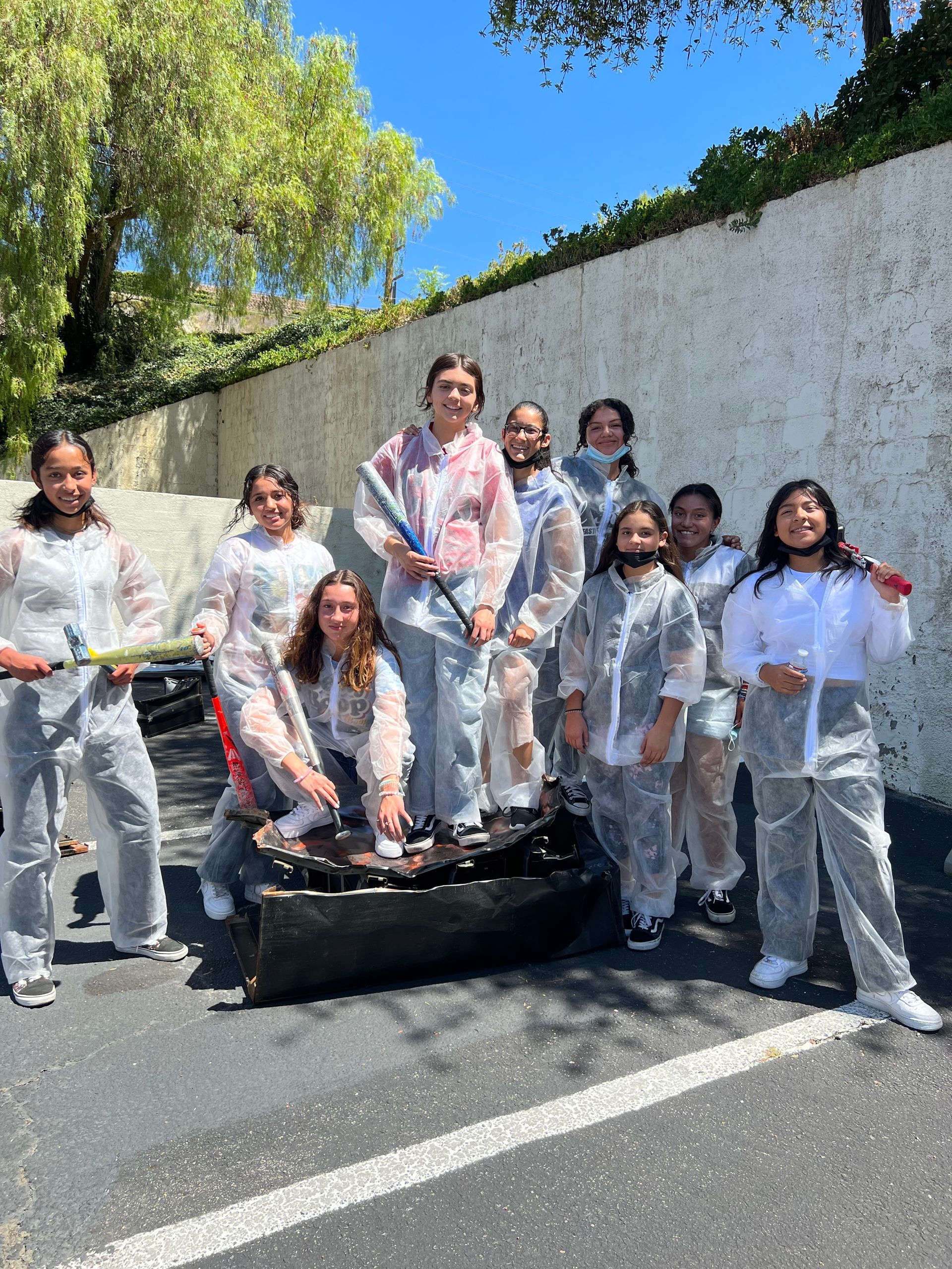 A group of people are standing next to each other in a parking lot.