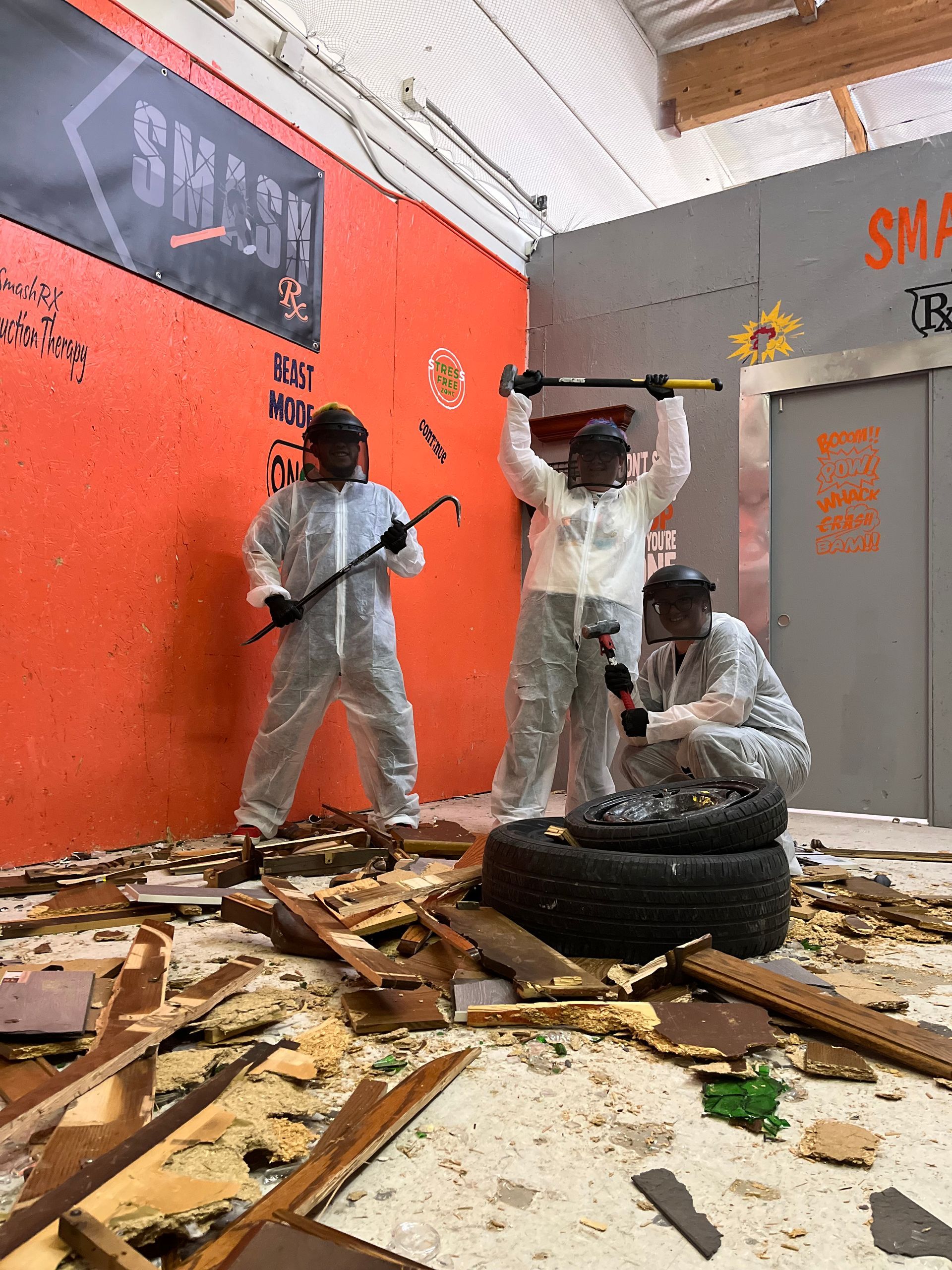 A group of people are standing in a room holding hammers.