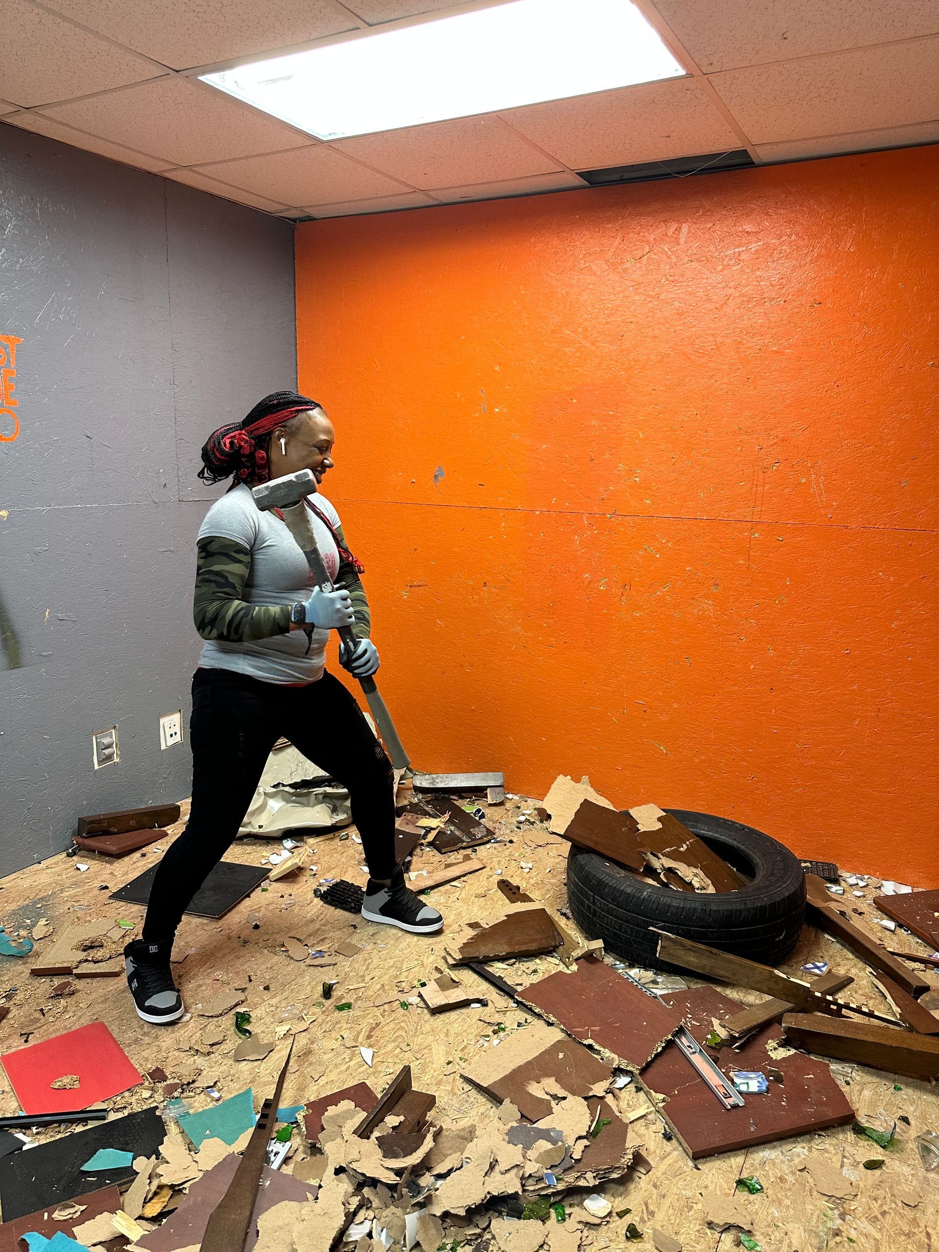 A woman is standing in a room with a tire on the floor.
