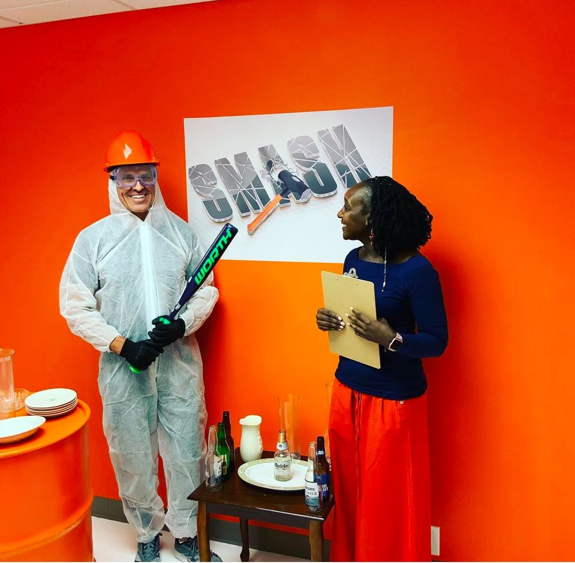 A man holding a baseball bat white talking to a woman.