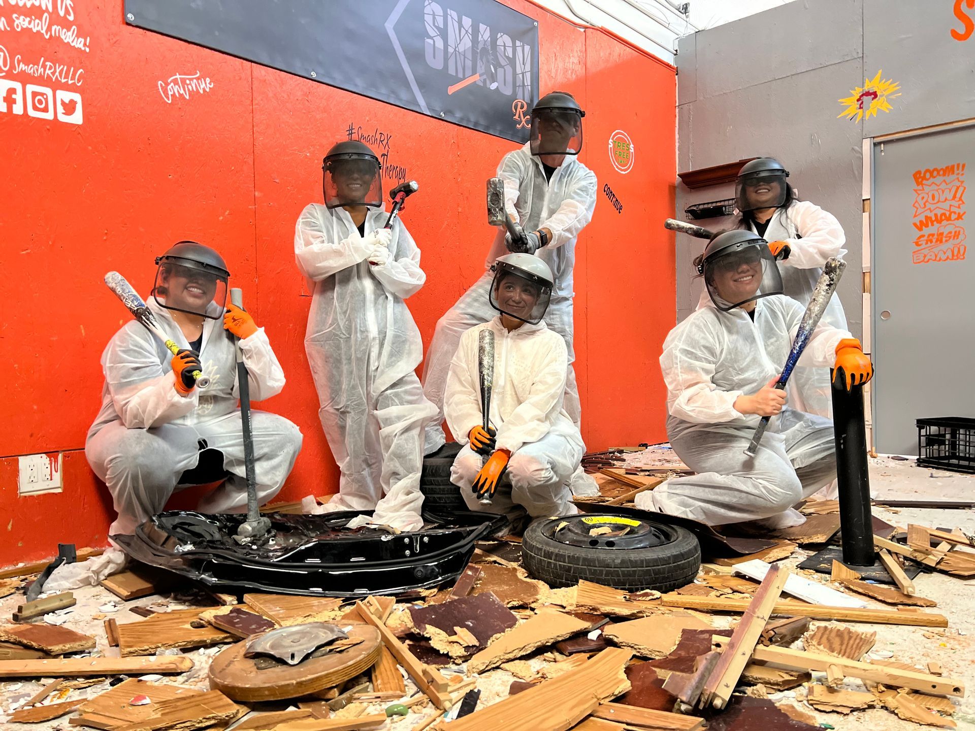 A group of people are sitting on the floor holding hammers and axes.