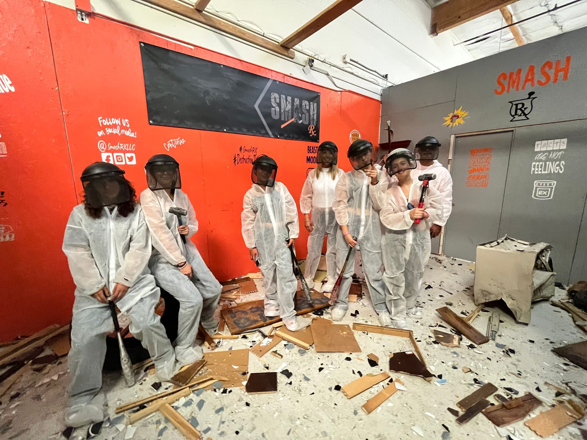 A group of people are standing in a room with a lot of trash.