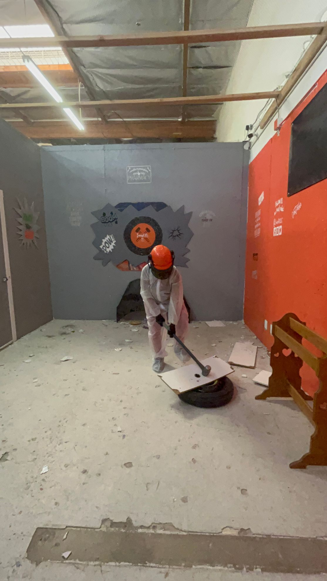 A person is breaking a tire with a hammer in a room.