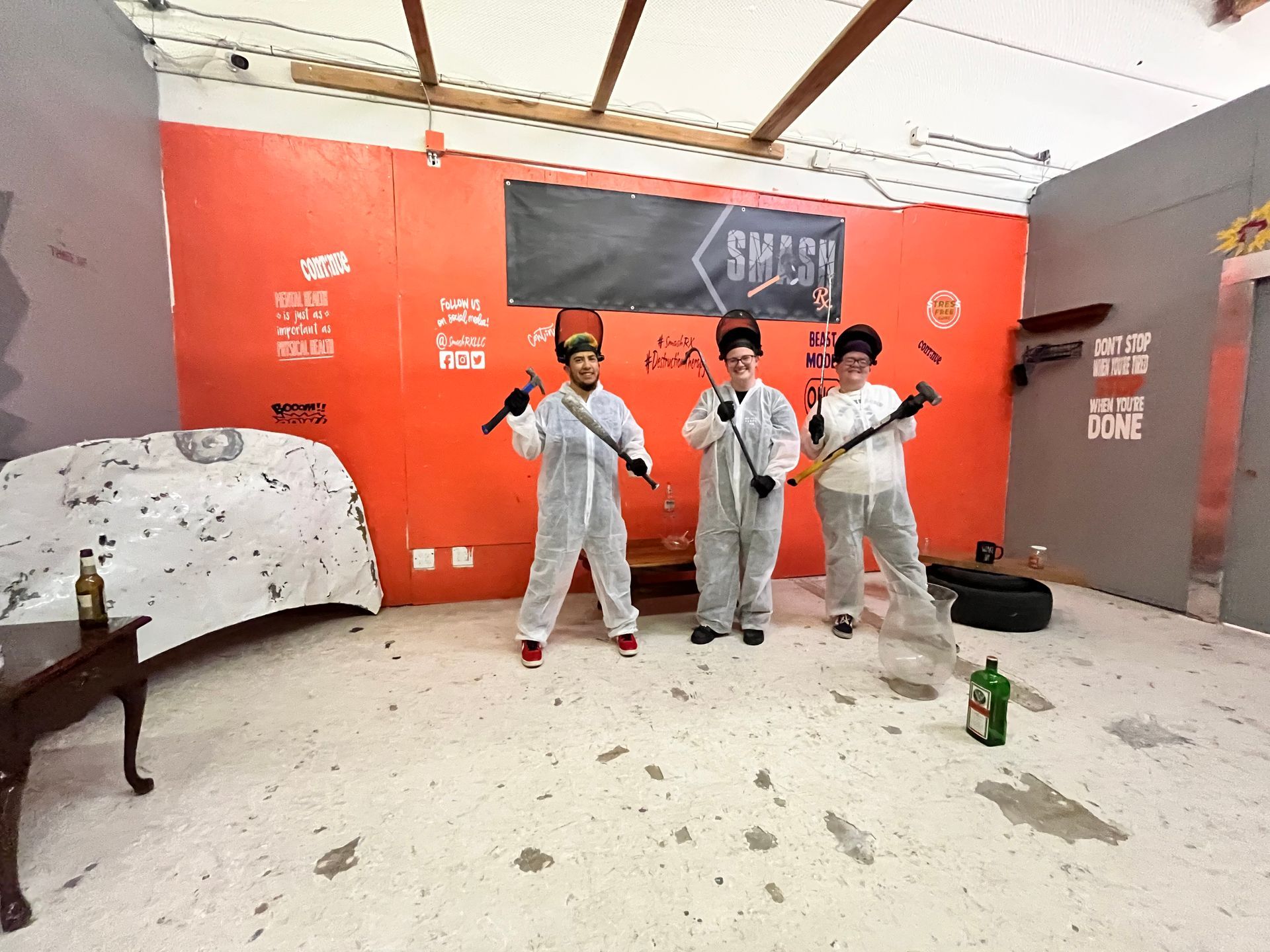 A group of people are standing in a room holding hammers.