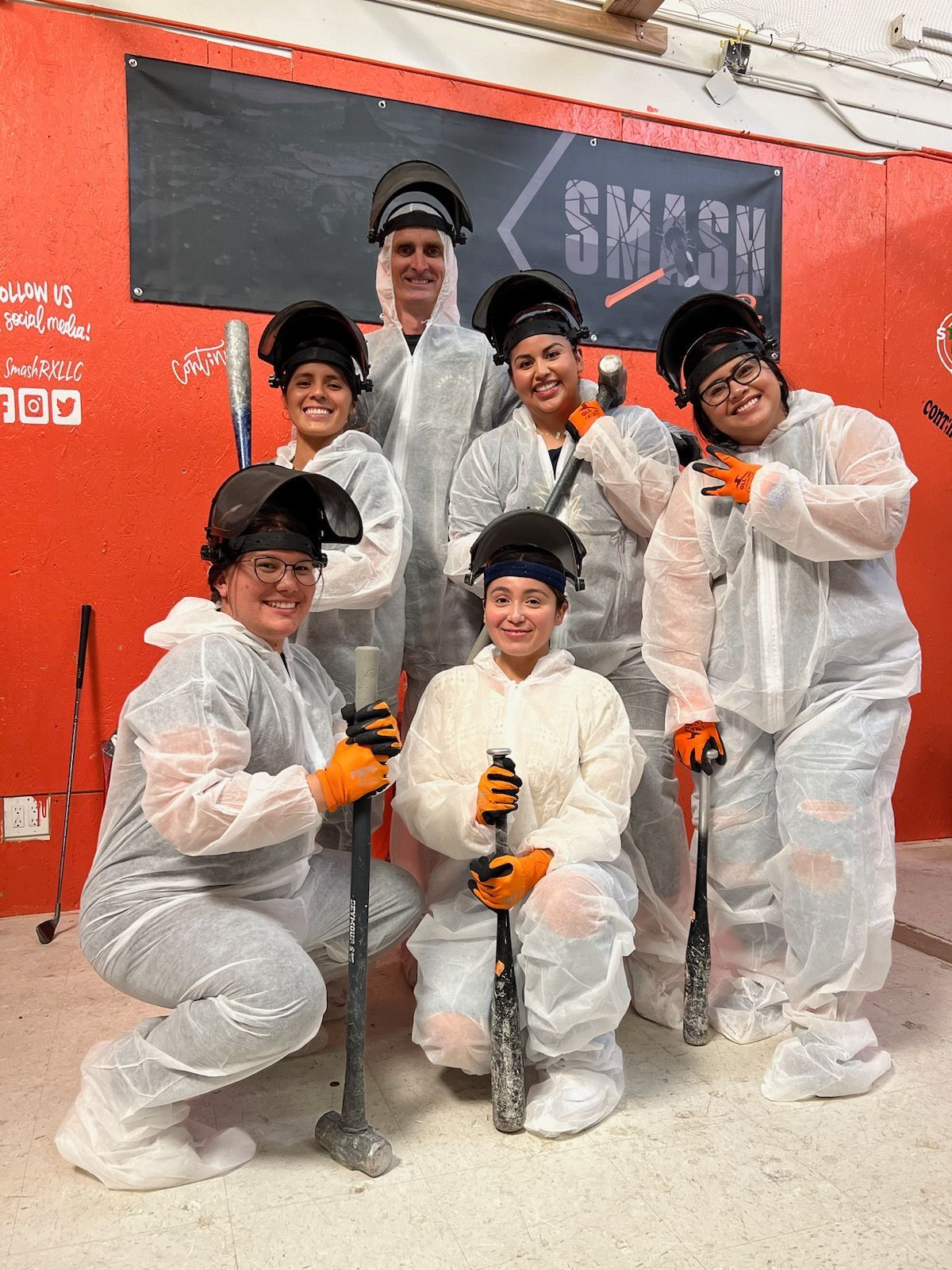 A group of people wearing welding helmets are posing for a picture.