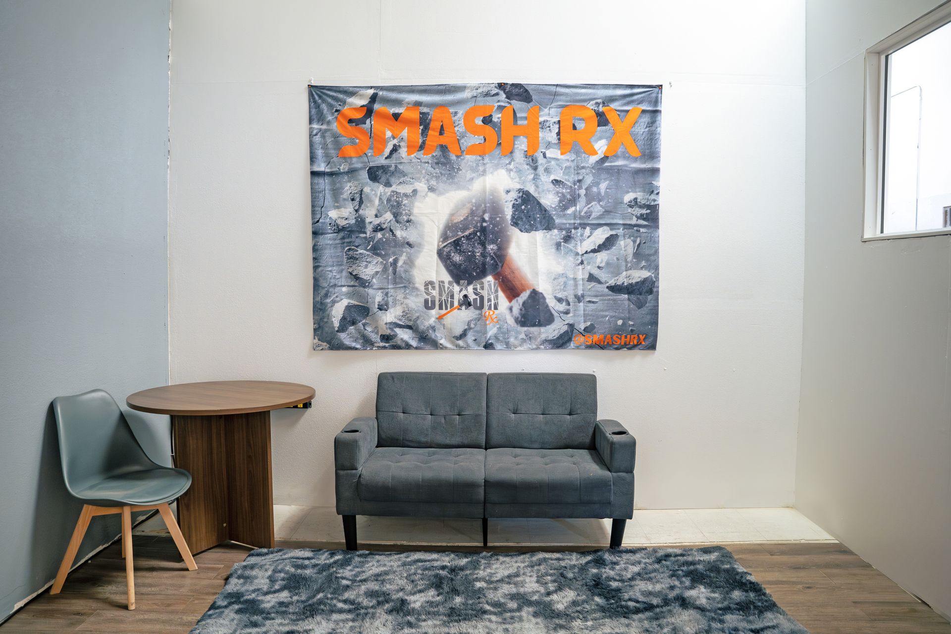 A living room with a couch , chair , table and a painting on the wall.