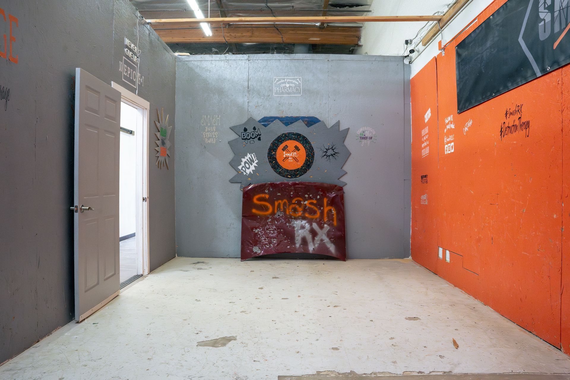 An empty room with a sign on the wall that says smash rx.