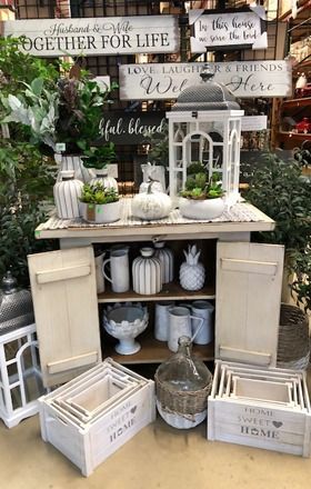 Decor display with signs, white vases, and decor in a store setting.