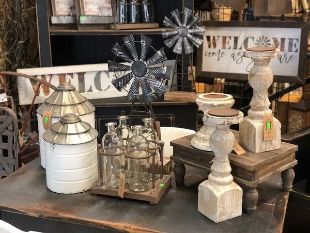 Farmhouse decor display: white and metal containers, windmill, candle holders, and