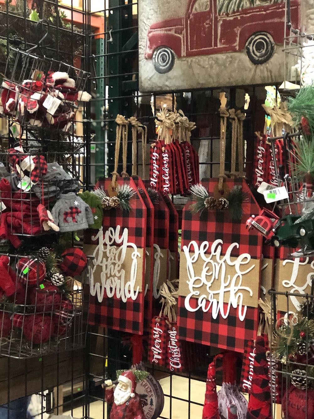 Christmas decorations, including buffalo plaid signs with festive phrases and a red truck.
