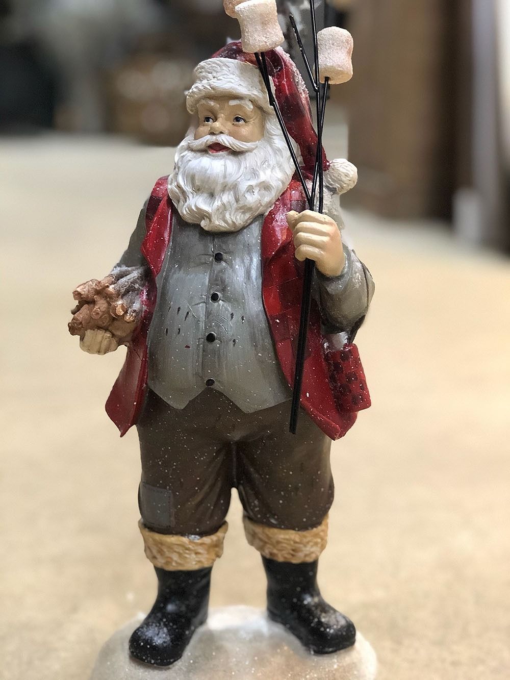 Santa Claus figurine with marshmallows on a stick, wearing a red coat and boots.