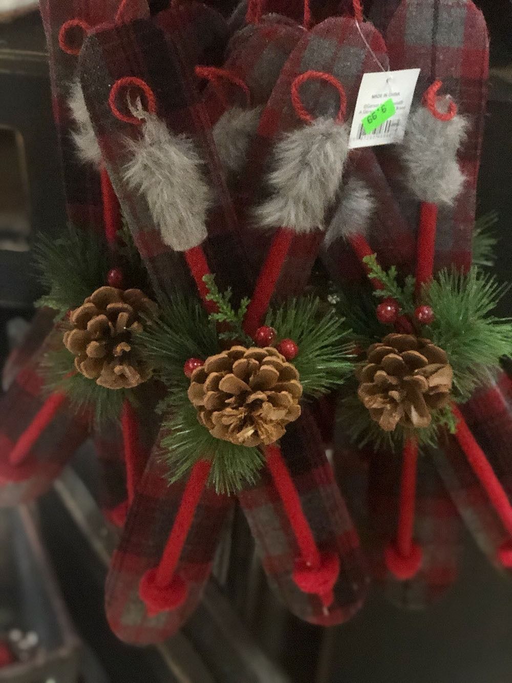 Christmas mitten ornaments with red and black plaid, pinecones, and greenery.