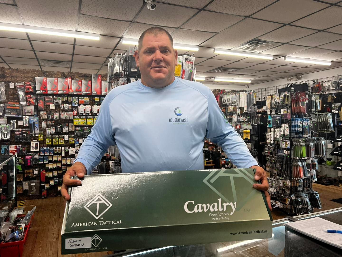 A man in a blue shirt is holding a box that says cavalry