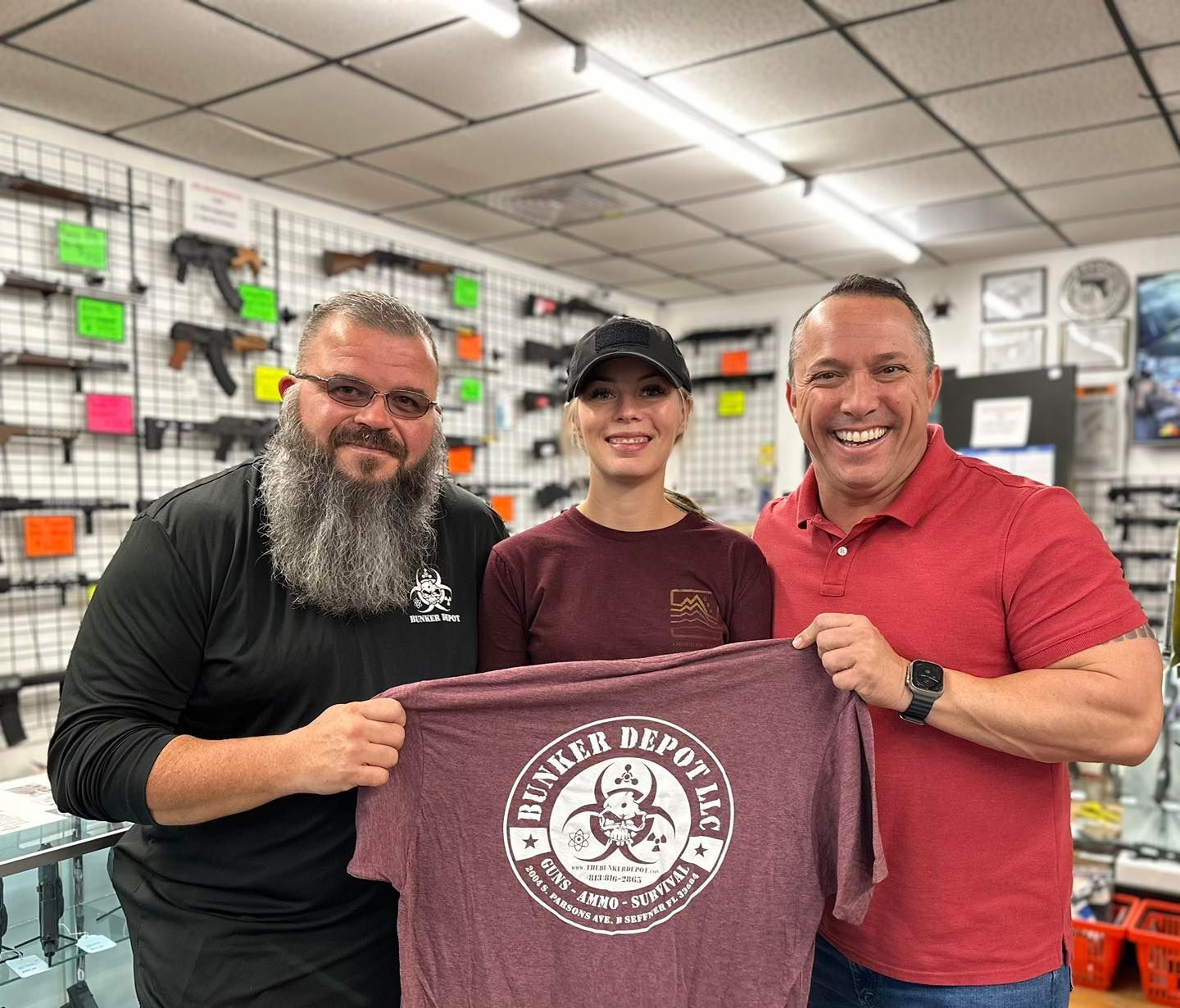 Three men are standing next to each other in a store holding a t-shirt.