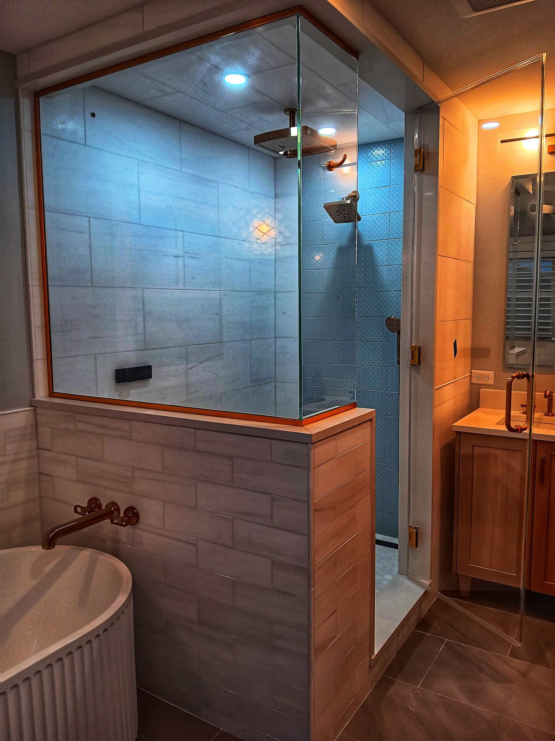 Modern bathroom with a glass shower, soaking tub, and wooden vanity.