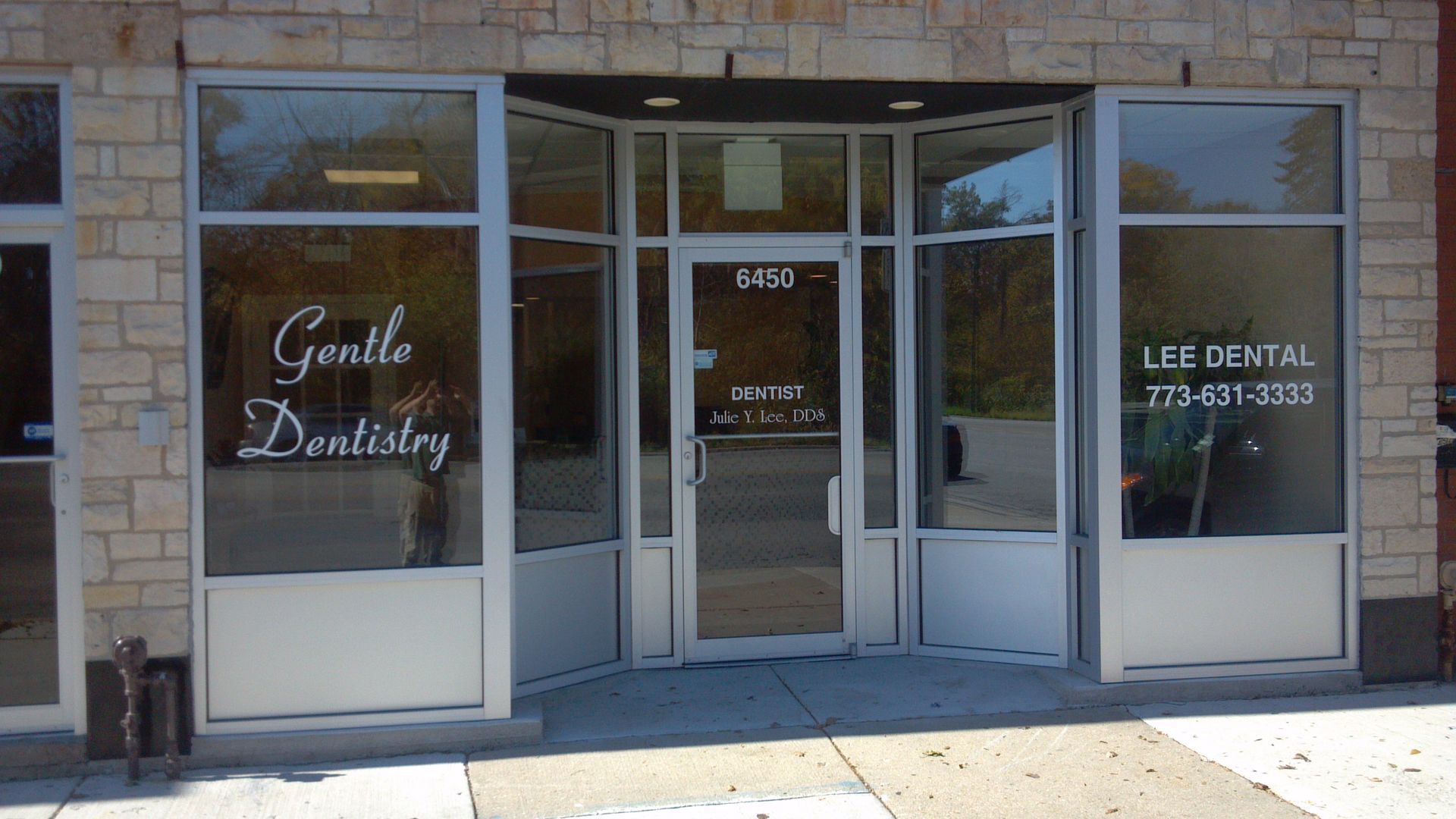 Exterior of a dental office with large windows. Text reads 
