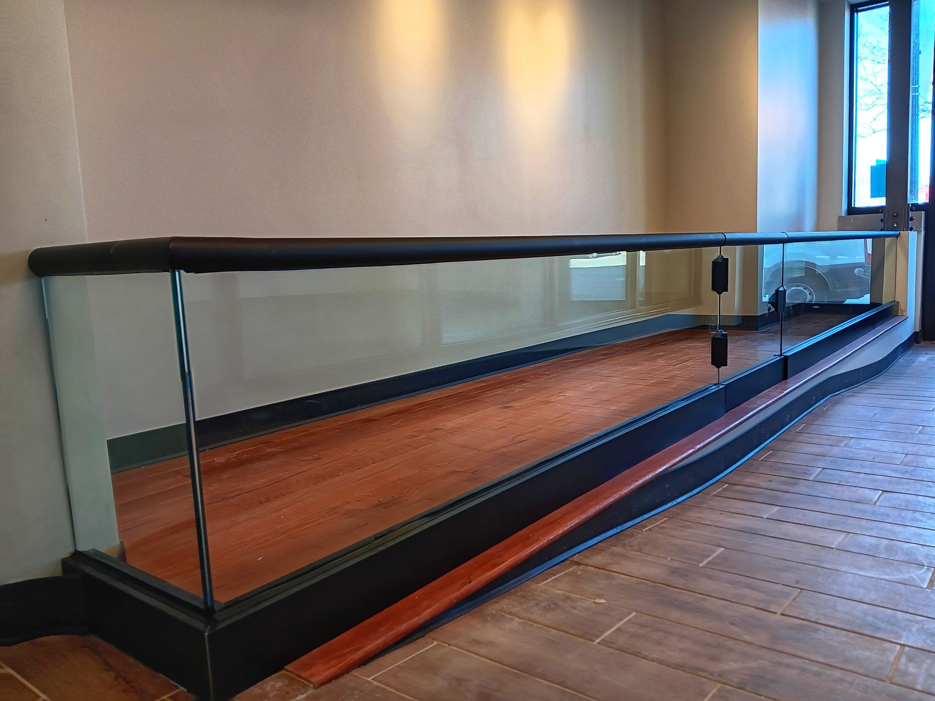 Shuffleboard table with wooden surface and glass sides, set in a room with light-colored walls.