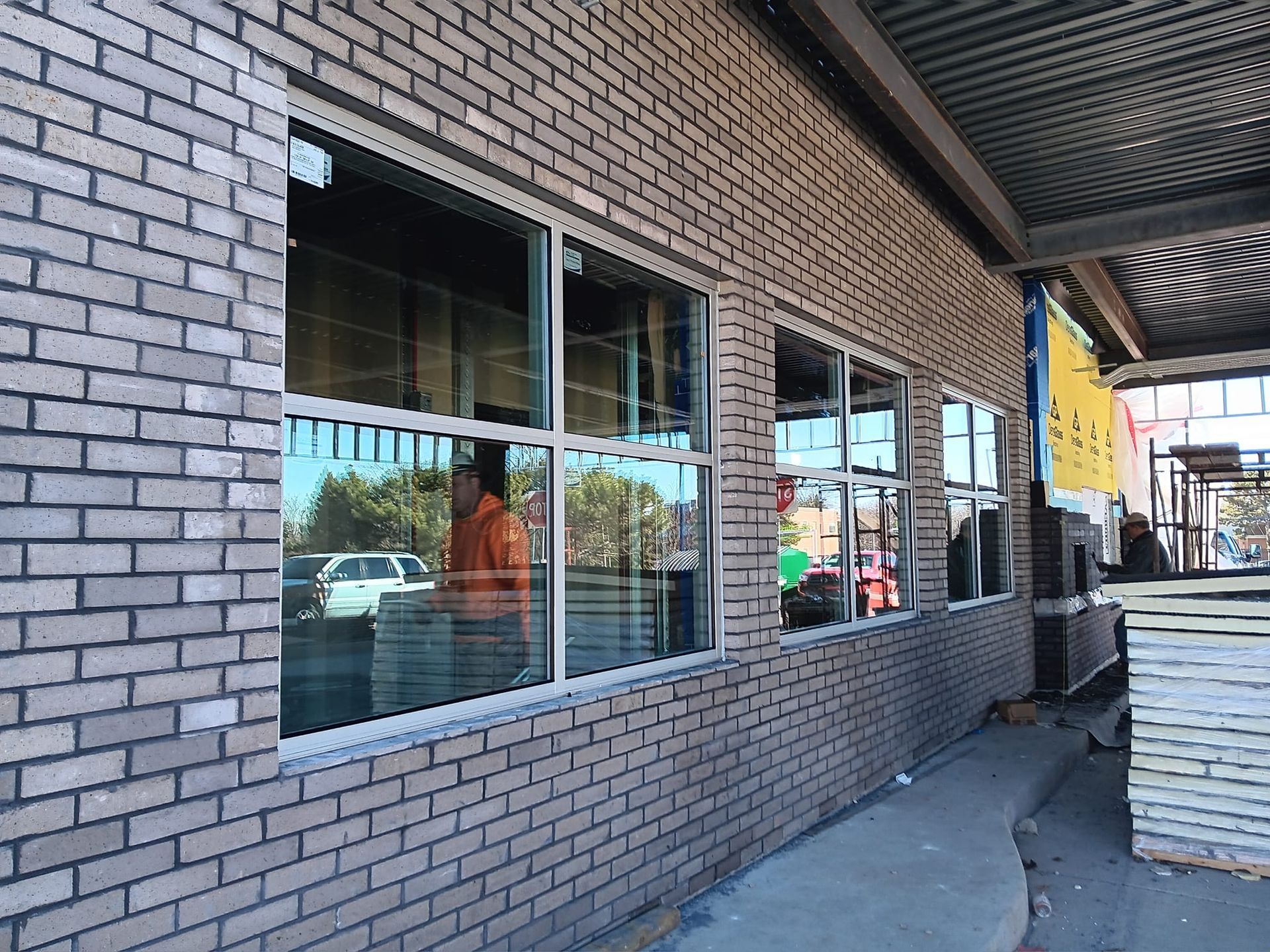 Brick building with windows, a person visible inside.