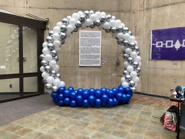 a large arch made of blue and silver balloons in a room