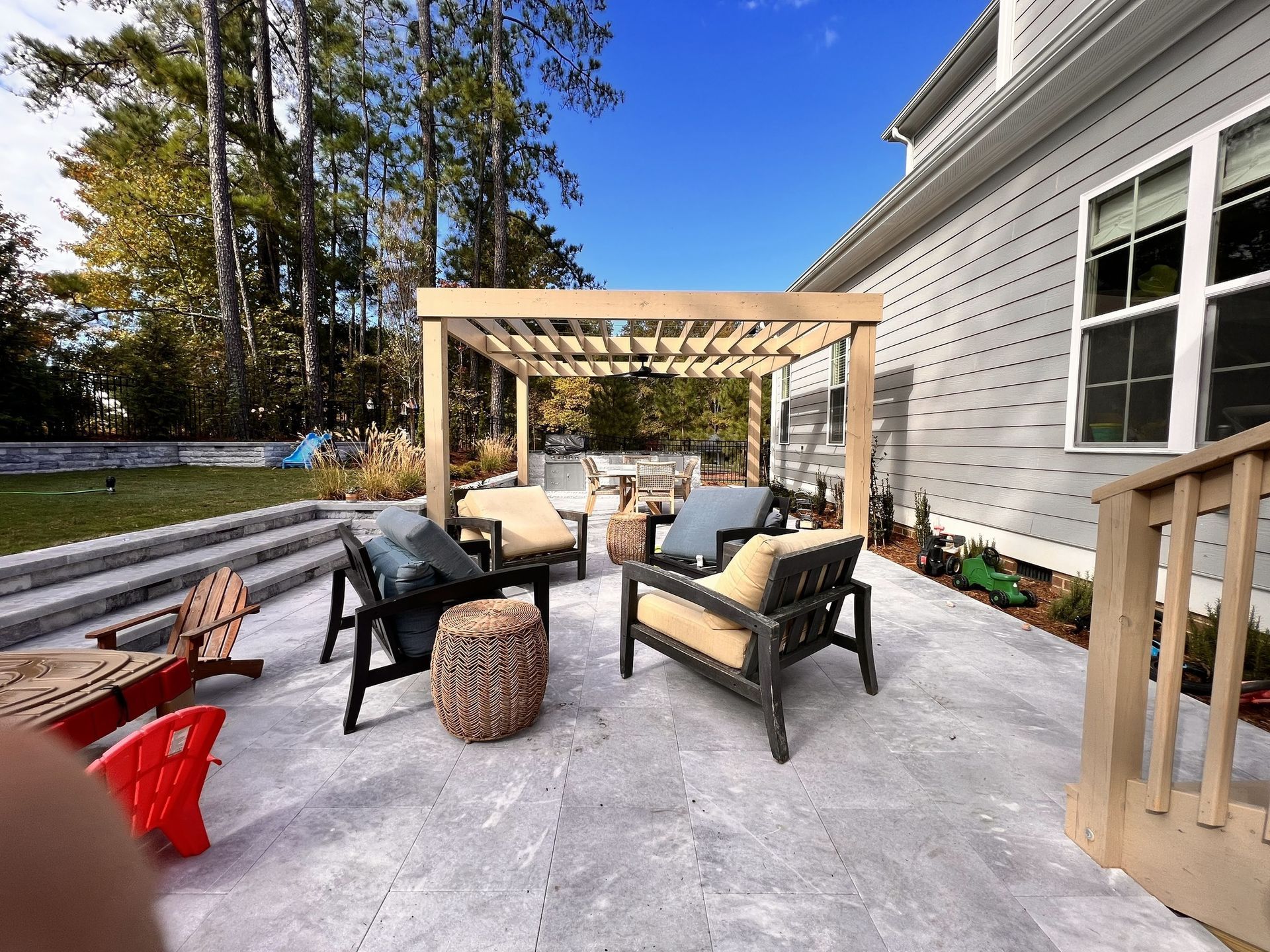 patio with pergola, seating, and house on a sunny day