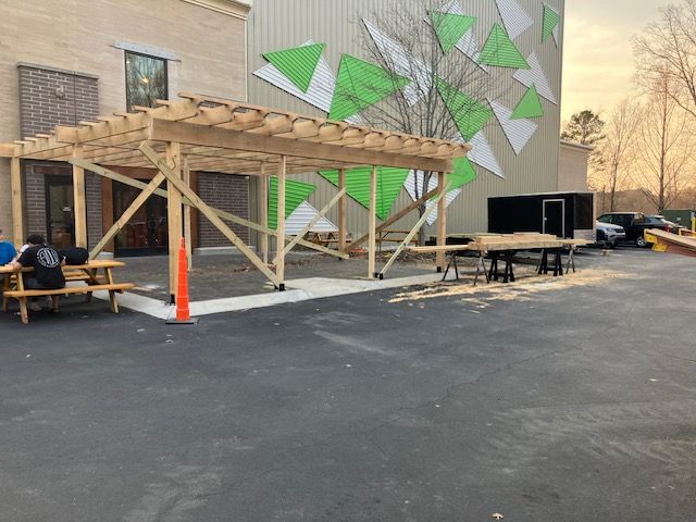 wooden pergola under construction near a building