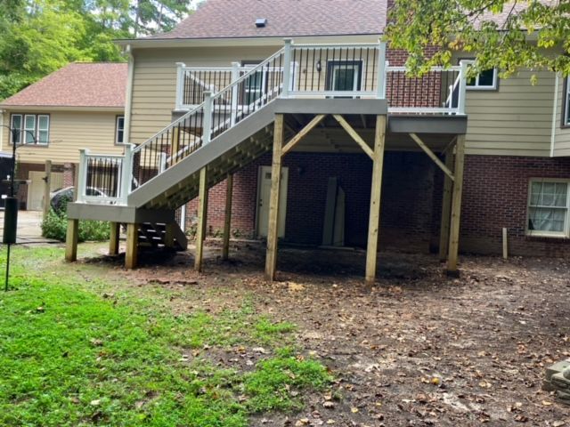 backyard deck with stairs leading down, supported by wooden posts