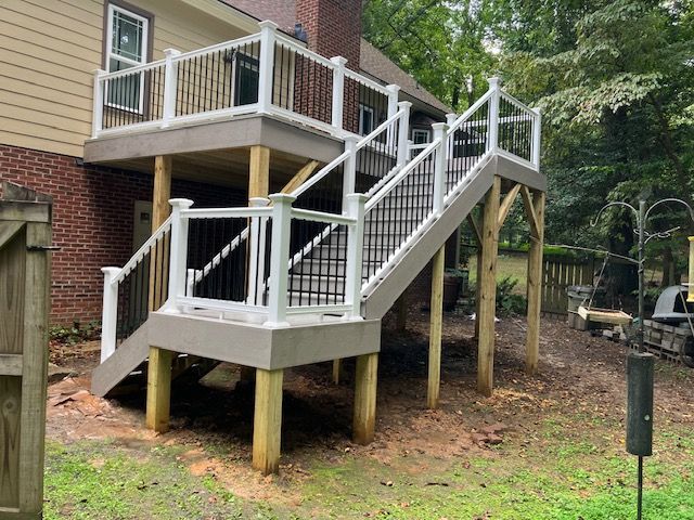 multi-level deck with white railings, black balusters, and steps