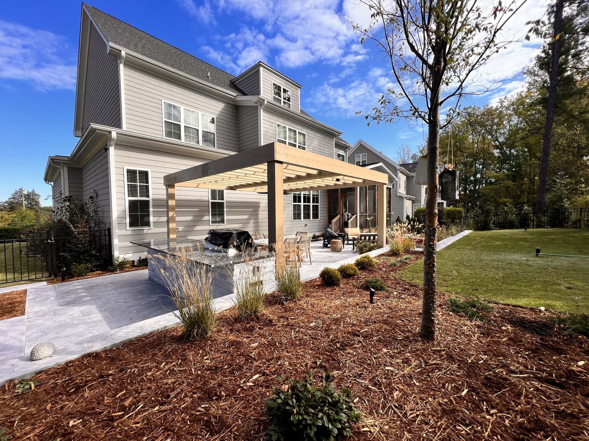 A large white house with a pergola in the backyard