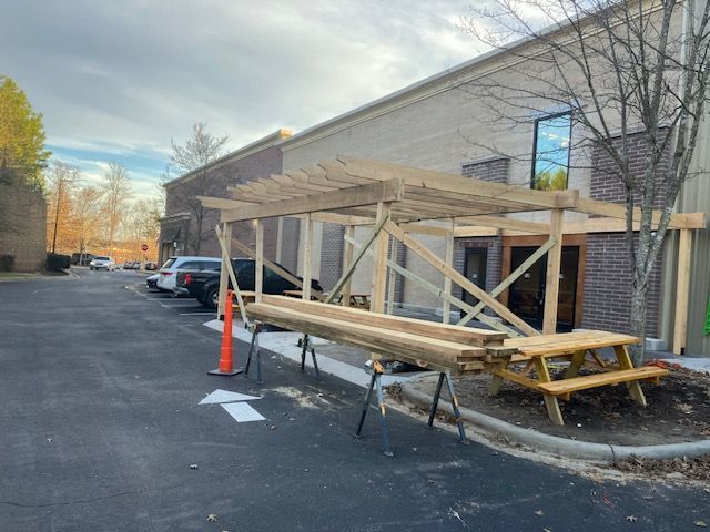 A wooden pergola is being built in front of a building