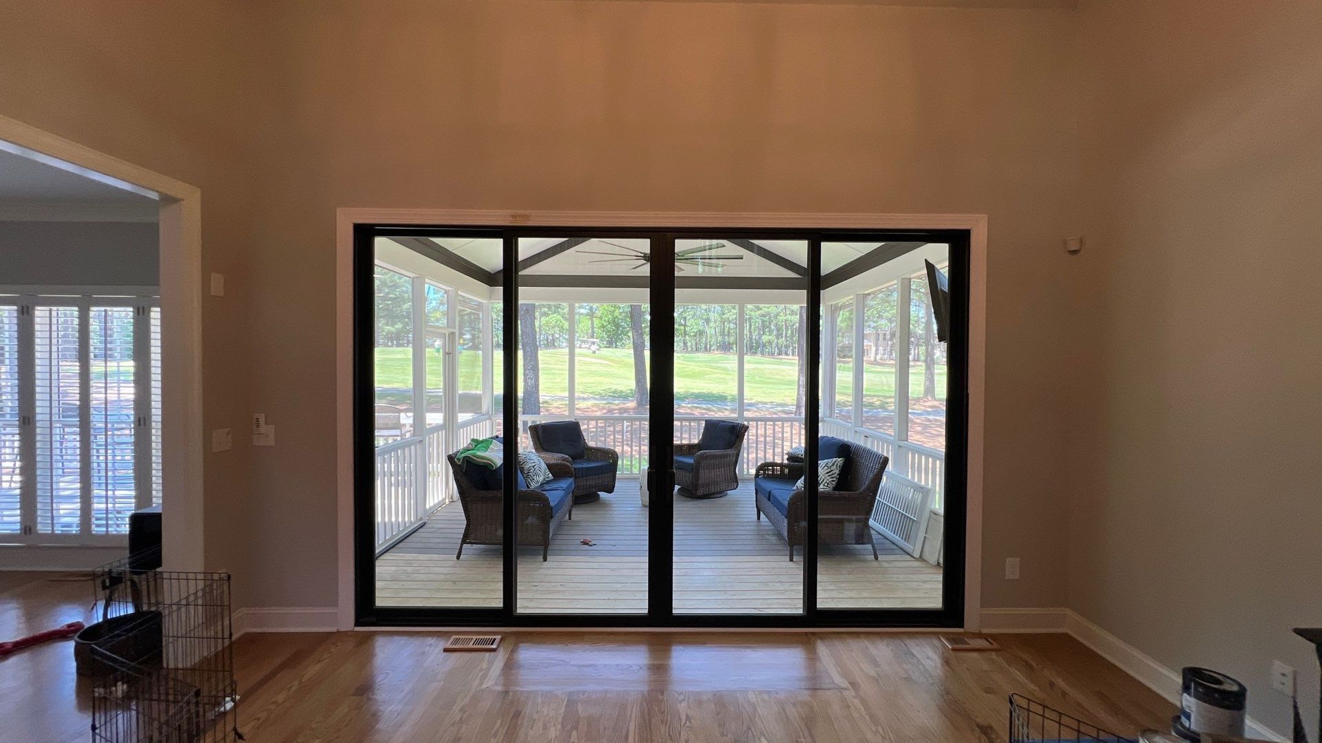 A living room with sliding glass doors leading to a screened in porch