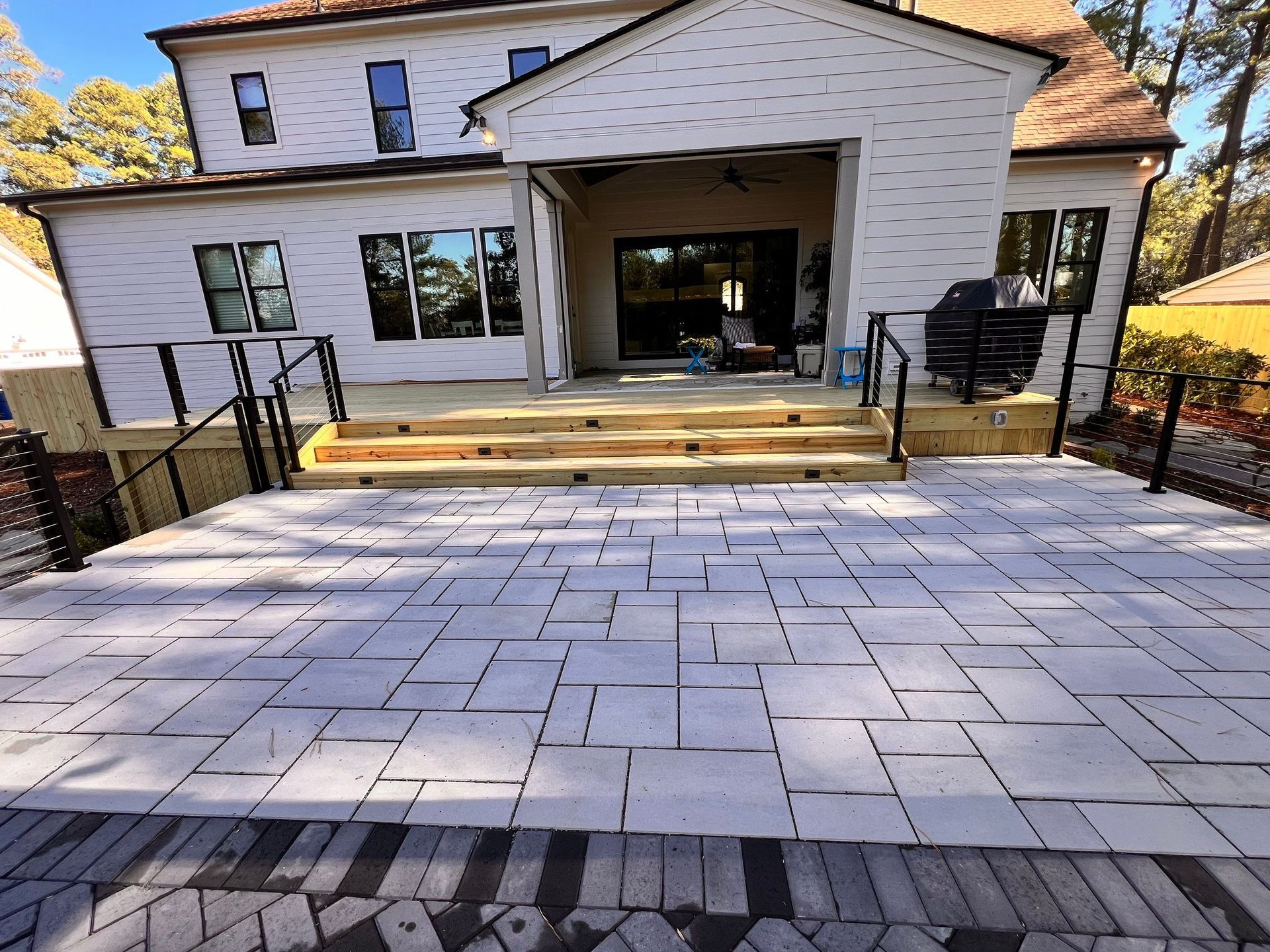 A large white house with a brick driveway in front of it